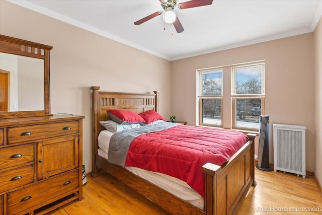 bedroom with crown molding, radiator heating unit, ceiling fan, and light hardwood / wood-style flooring