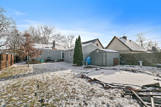 snow covered property featuring a storage unit