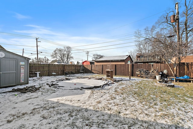 yard layered in snow featuring a storage shed