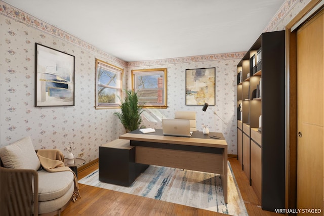 office space with wallpapered walls, light wood-style flooring, and baseboards