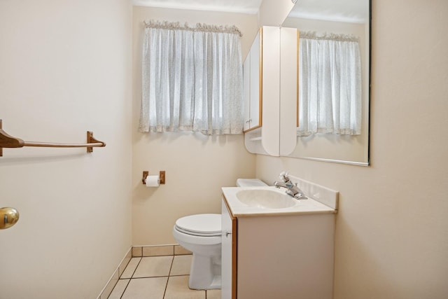 bathroom with toilet, tile patterned flooring, vanity, and baseboards