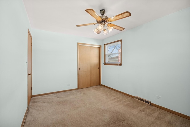 unfurnished room featuring carpet, visible vents, ceiling fan, and baseboards