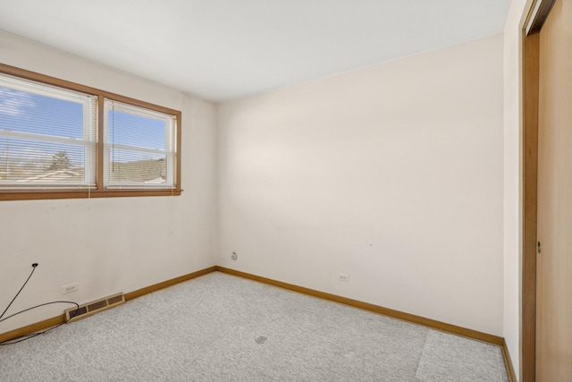 spare room with light colored carpet, visible vents, and baseboards