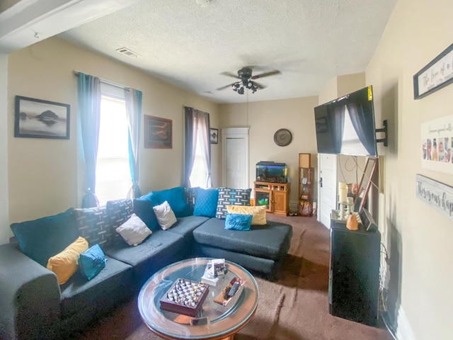 carpeted living room with ceiling fan and a textured ceiling