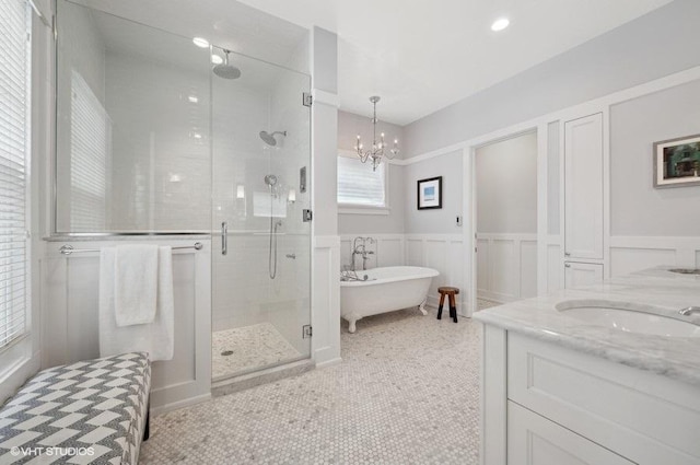 bathroom featuring a notable chandelier, plus walk in shower, tile patterned floors, and vanity