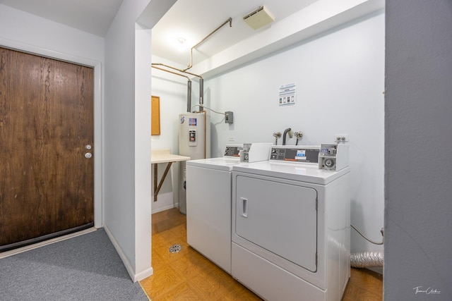 washroom with water heater and independent washer and dryer