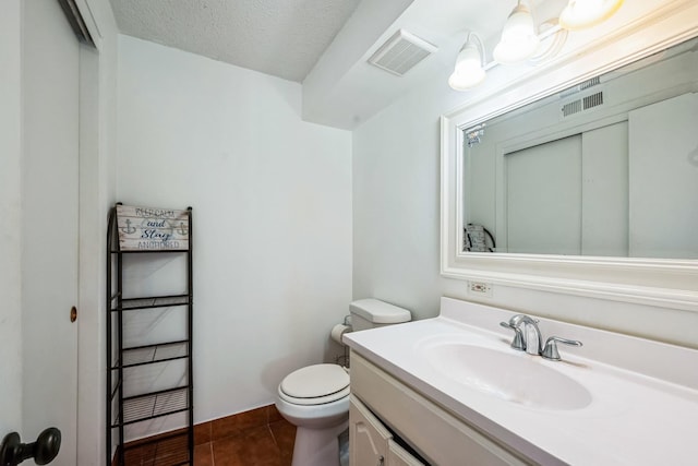 bathroom featuring vanity, tile patterned floors, toilet, and a textured ceiling