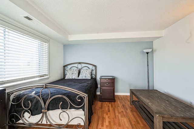 bedroom featuring wood-type flooring and a textured ceiling