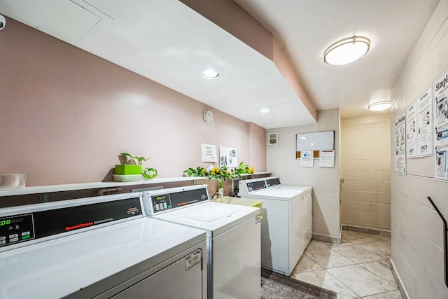 clothes washing area featuring separate washer and dryer and light tile patterned floors