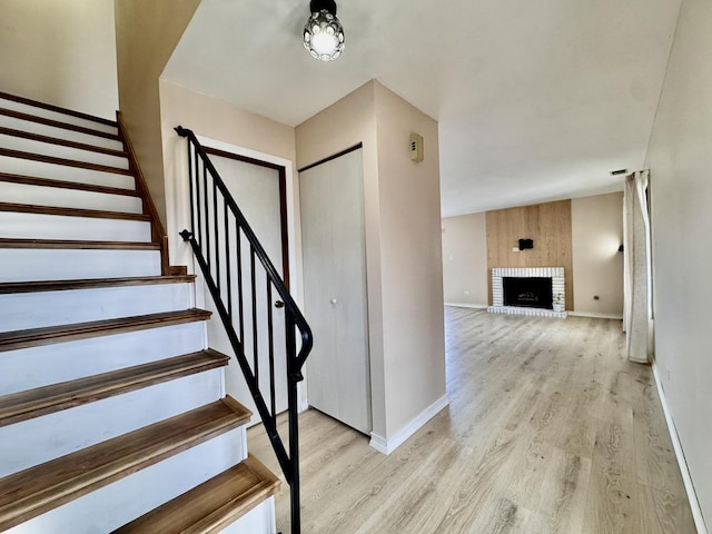 stairway featuring hardwood / wood-style flooring and a fireplace