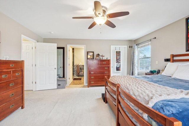 carpeted bedroom featuring ceiling fan and ensuite bath