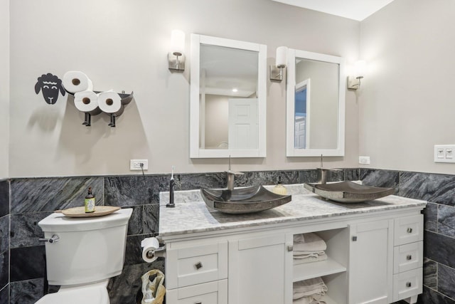 bathroom featuring tile walls, vanity, and toilet