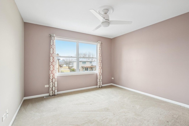 carpeted spare room with ceiling fan