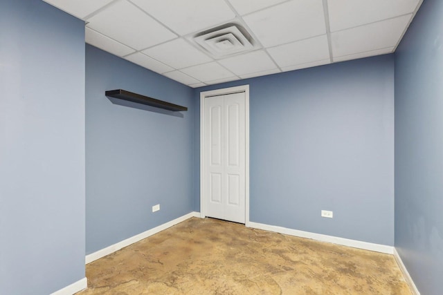 spare room with concrete flooring and a drop ceiling