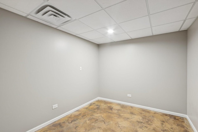 unfurnished room with a paneled ceiling and concrete floors