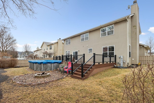 back of house with a yard and a swimming pool side deck