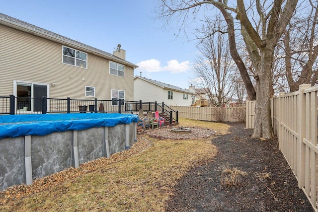 exterior space featuring a fire pit and a covered pool