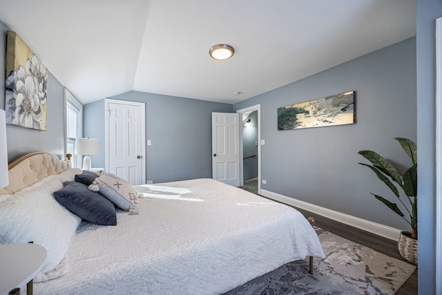 bedroom with lofted ceiling and dark hardwood / wood-style flooring