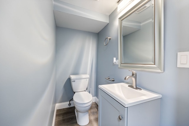 bathroom with vanity, wood-type flooring, and toilet