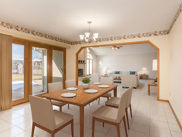 tiled dining area with a notable chandelier, a fireplace, and a wealth of natural light