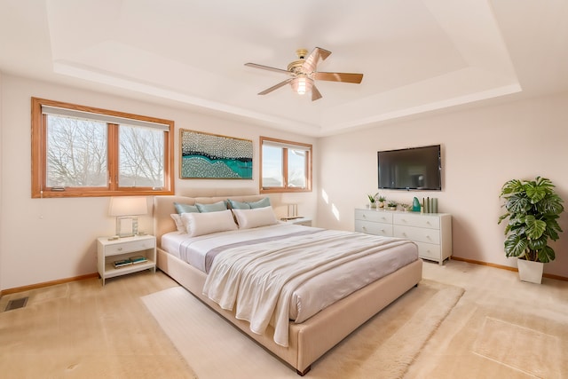 bedroom with a tray ceiling and ceiling fan