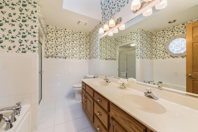 full bathroom with tile walls, vanity, tile patterned floors, independent shower and bath, and toilet