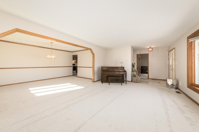 interior space featuring light colored carpet and a chandelier