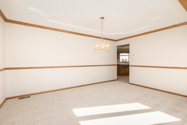 empty room featuring crown molding, a chandelier, and carpet