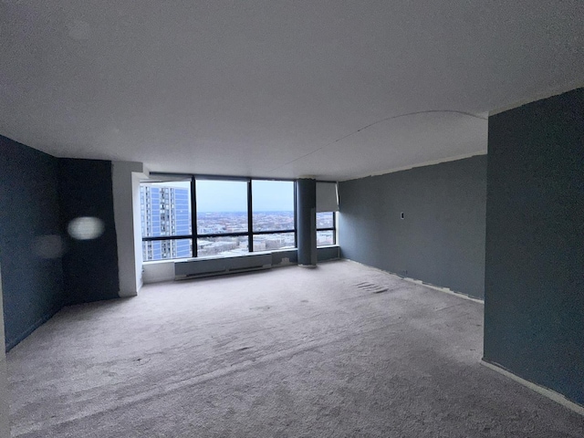 unfurnished living room with a baseboard radiator, a water view, and carpet