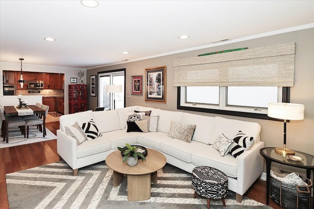 living room featuring crown molding, wood-type flooring, and a wealth of natural light