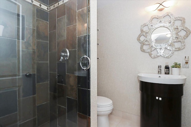 bathroom featuring tile patterned floors, vanity, toilet, and a shower with door