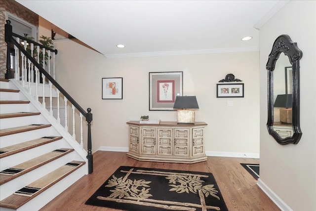 foyer with hardwood / wood-style flooring and crown molding