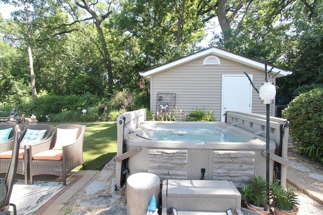 view of patio / terrace featuring an outbuilding and a hot tub