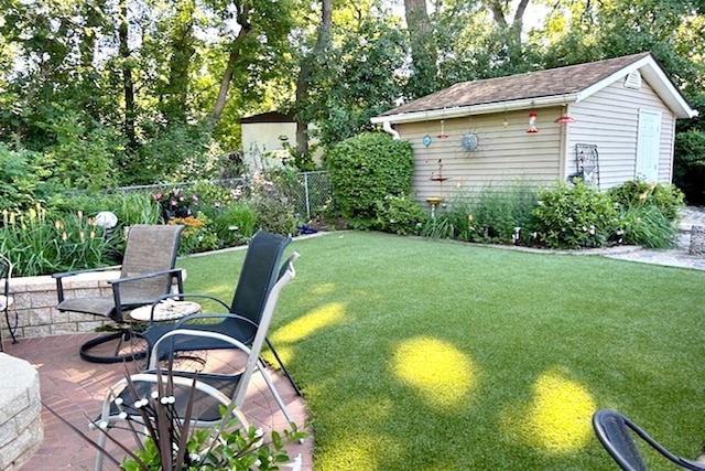 view of yard featuring a patio and an outbuilding