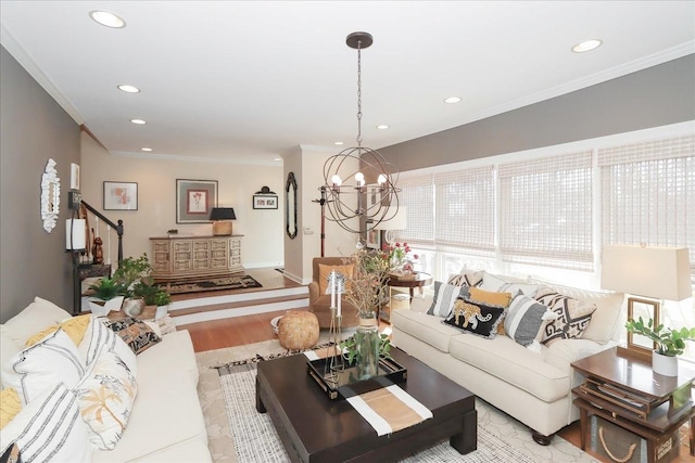 living room with ornamental molding, a chandelier, and light hardwood / wood-style flooring