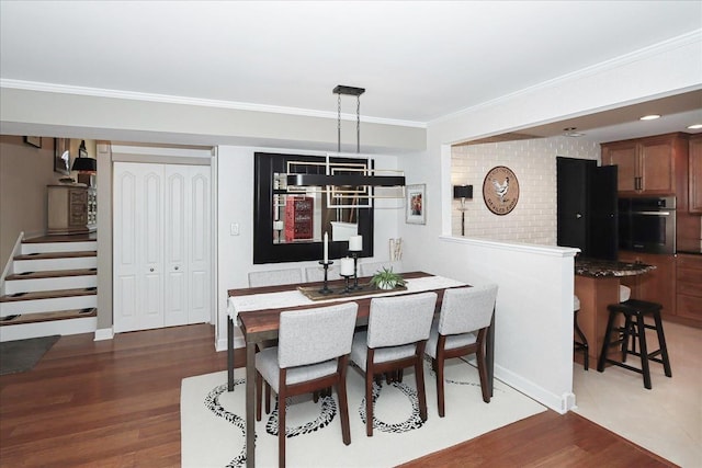 dining room with ornamental molding and dark hardwood / wood-style flooring