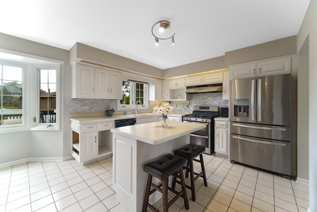 12850 S Westport Dr, Palos Park, IL 60464 - kitchen with appliances with stainless steel finishes, under cabinet range hood, light countertops, and light tile patterned floors