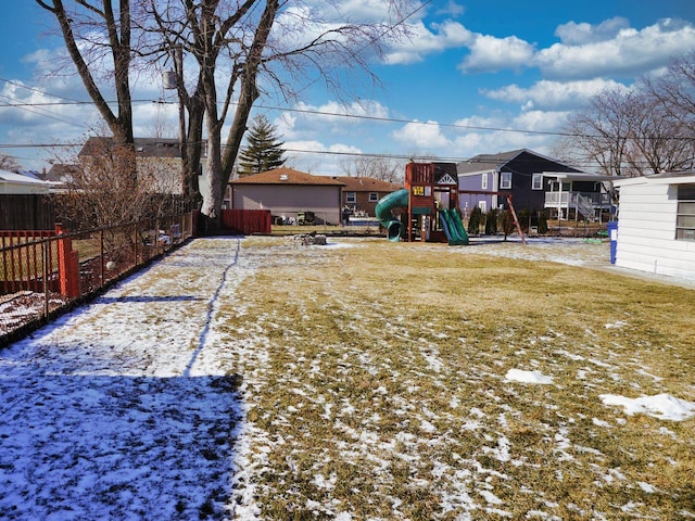 yard layered in snow featuring a playground