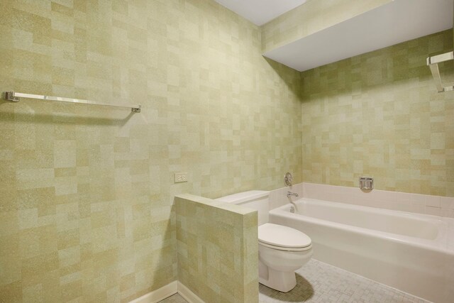bathroom featuring toilet, a bath, and tile patterned flooring