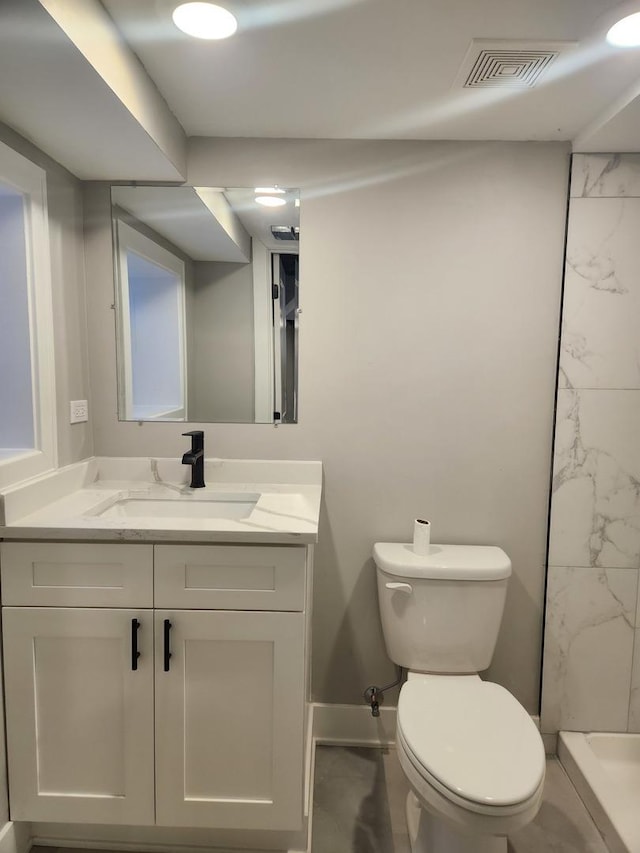 bathroom featuring vanity, walk in shower, and toilet