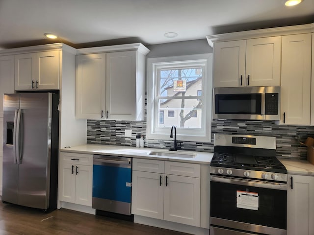 kitchen with white cabinetry, sink, backsplash, and stainless steel appliances