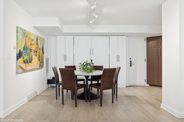 dining space featuring track lighting and light hardwood / wood-style floors