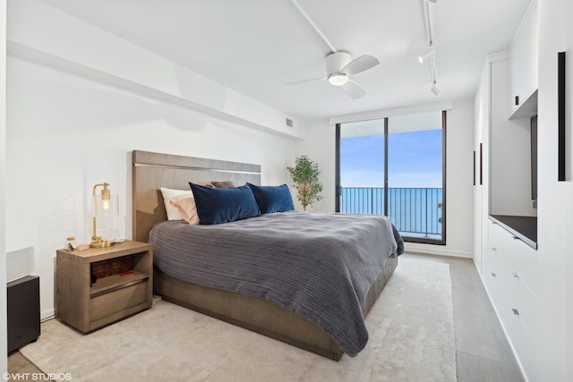 bedroom featuring ceiling fan, rail lighting, and access to outside