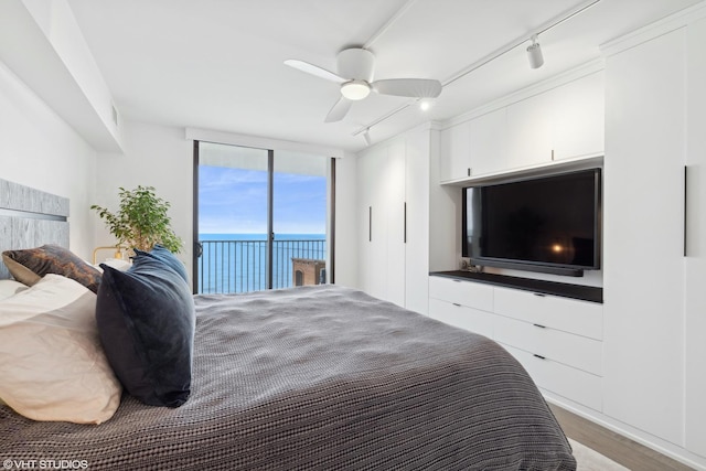 bedroom with hardwood / wood-style flooring, ceiling fan, floor to ceiling windows, track lighting, and access to outside