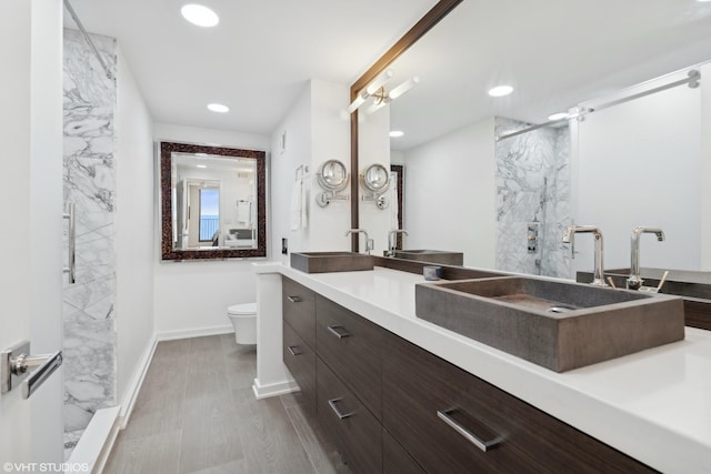 bathroom with vanity, toilet, an enclosed shower, and hardwood / wood-style floors