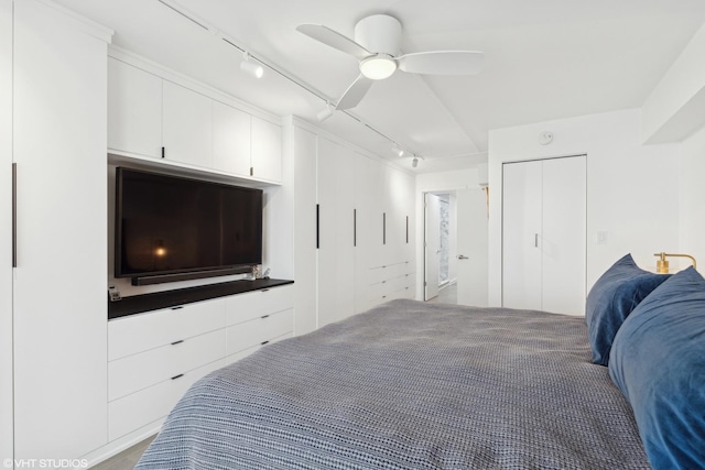 bedroom featuring track lighting, ceiling fan, and a closet