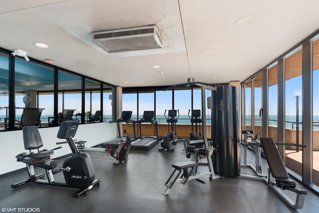 exercise room featuring a wall of windows and a water view