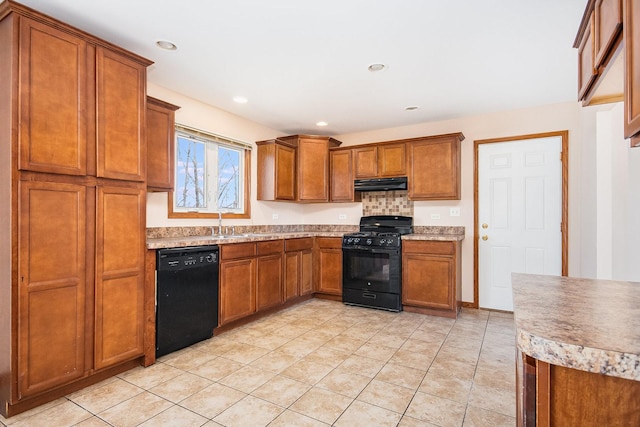 kitchen with light tile patterned floors, brown cabinetry, under cabinet range hood, light countertops, and black appliances