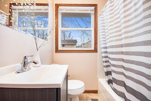 bathroom featuring toilet, baseboards, shower / bath combo with shower curtain, and vanity