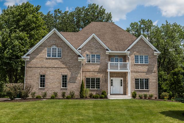 craftsman-style house with a balcony and a front lawn